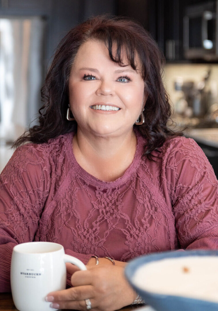 Lori Jackson A woman sitting at the table with a cup of coffee.