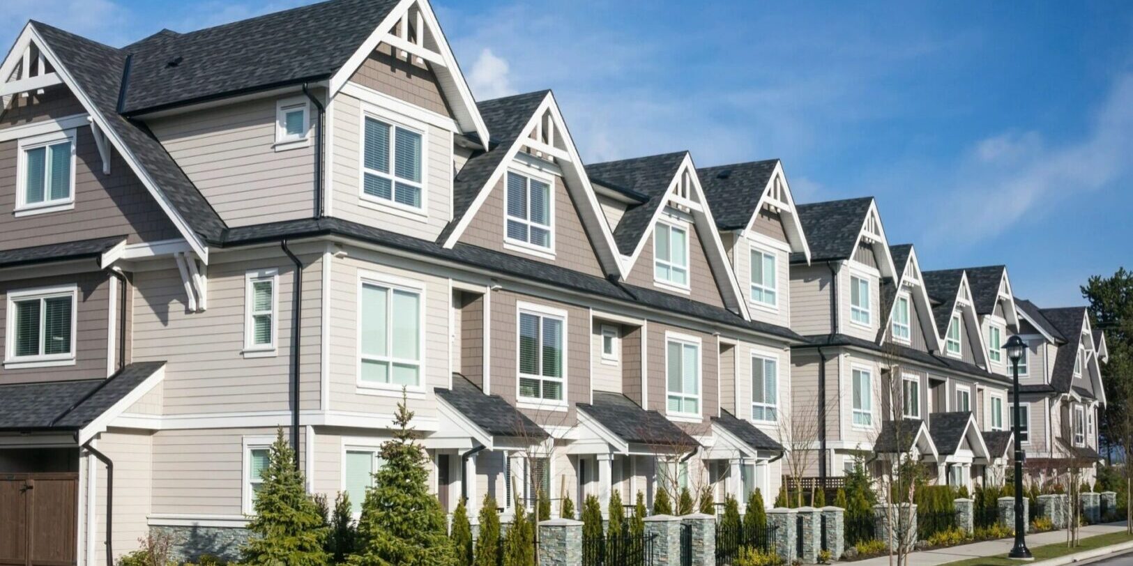 fm=f_1258 A row of houses with trees in front.
